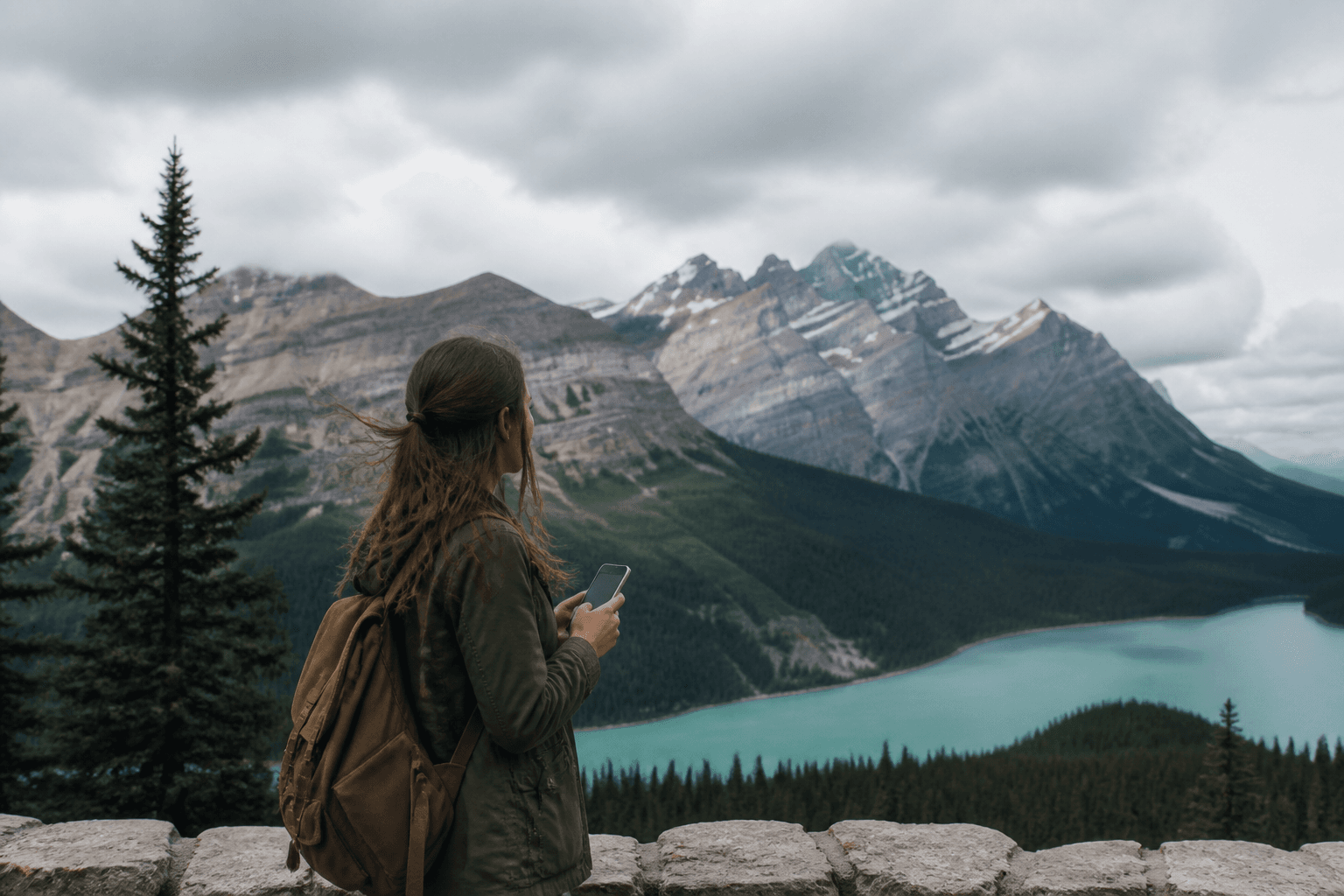 Traveller with an eSIM smartphone in front of the Canadian Rockies, eSIM Giga banner